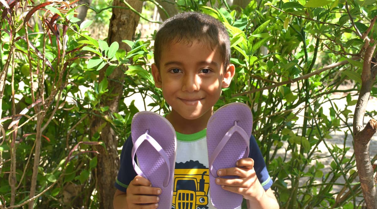 Volunteers distributing shoes to children